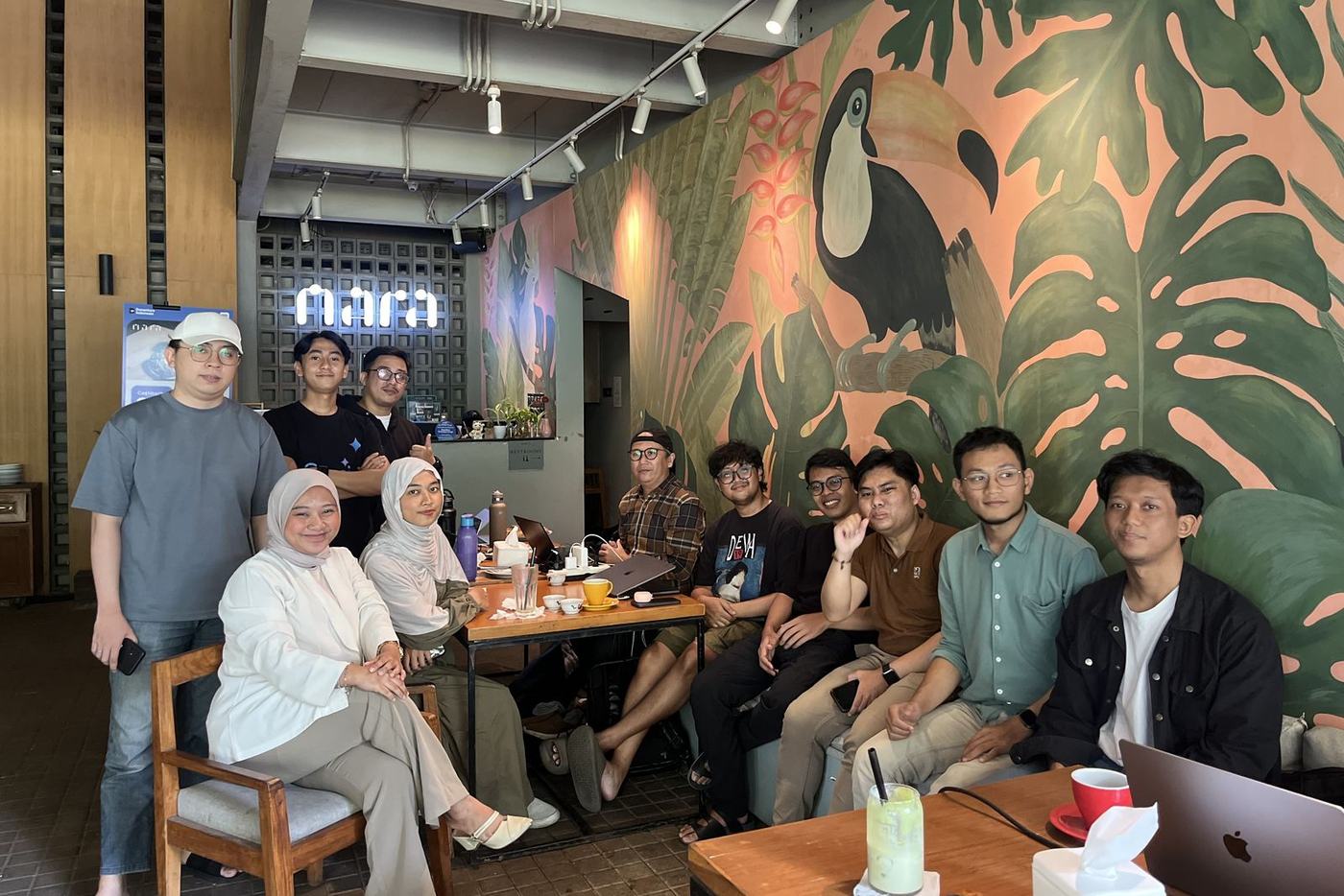 Peserta WFC berfoto bersama di depan mural tropis dan papan nama nara